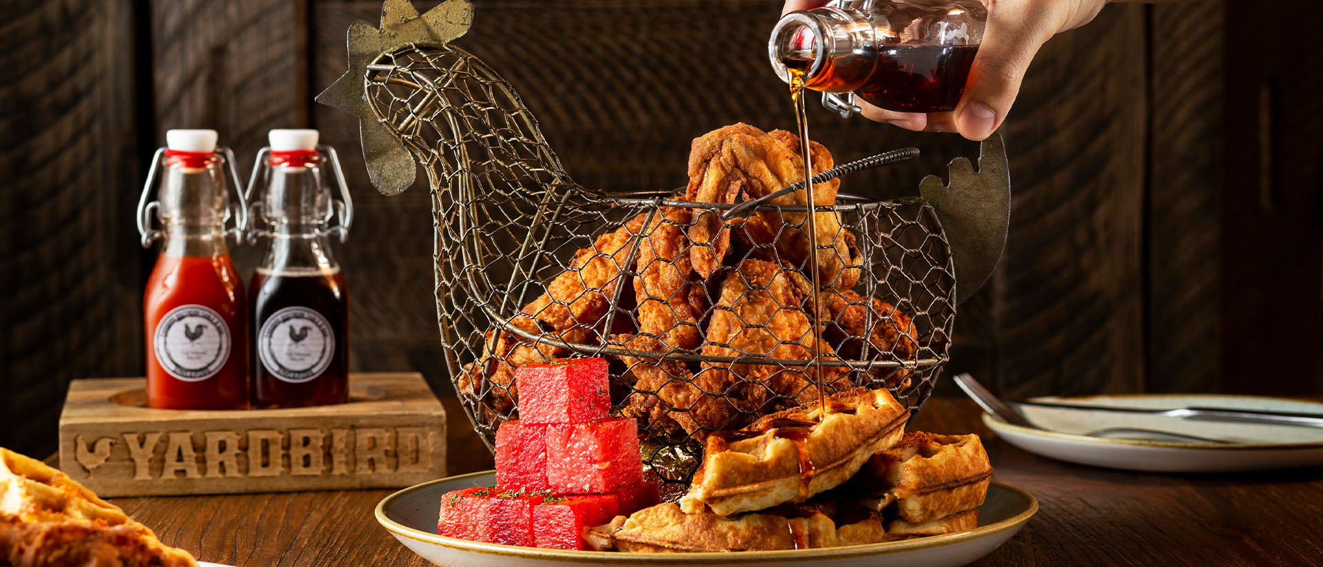 싱가포르 최고의 런치 명소인 Yardbird에서 프라이드 치킨 (Fried Chicken)에 소스를 붓고 있는 사람