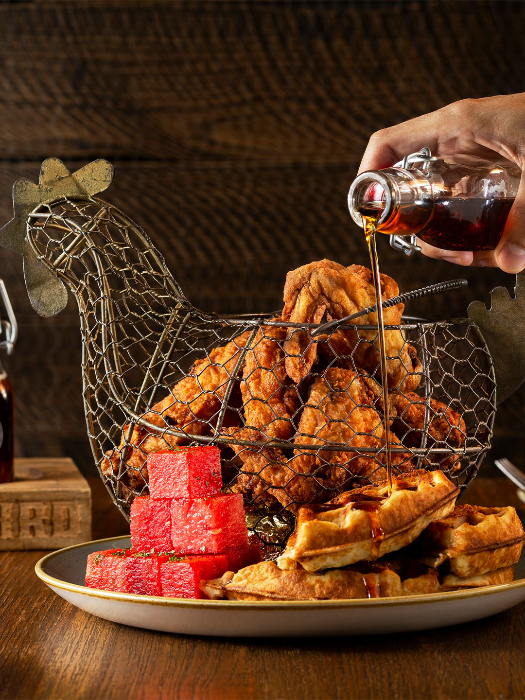 싱가포르 최고의 런치 명소인 Yardbird에서 프라이드 치킨 (Fried Chicken)에 소스를 붓고 있는 사람
