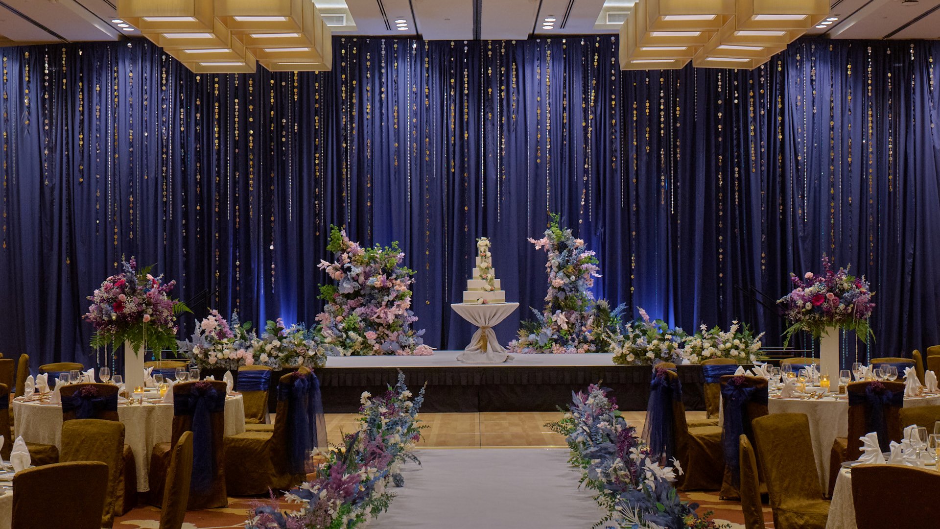 클래식한 파란색 배경과 꽃 장식이 있는 웨딩 무대