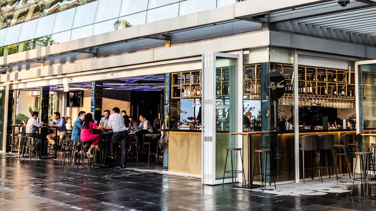 People enjoying after work drinks at an al fresco waterfront bar, Le Noir